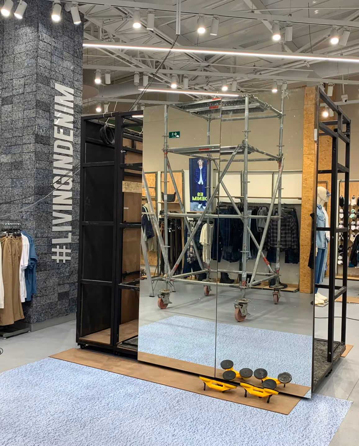 NEA Studio immersive retail experience, GEF interactive fitting room mirrored panels and digital screen being installed inside GEF fashion store
