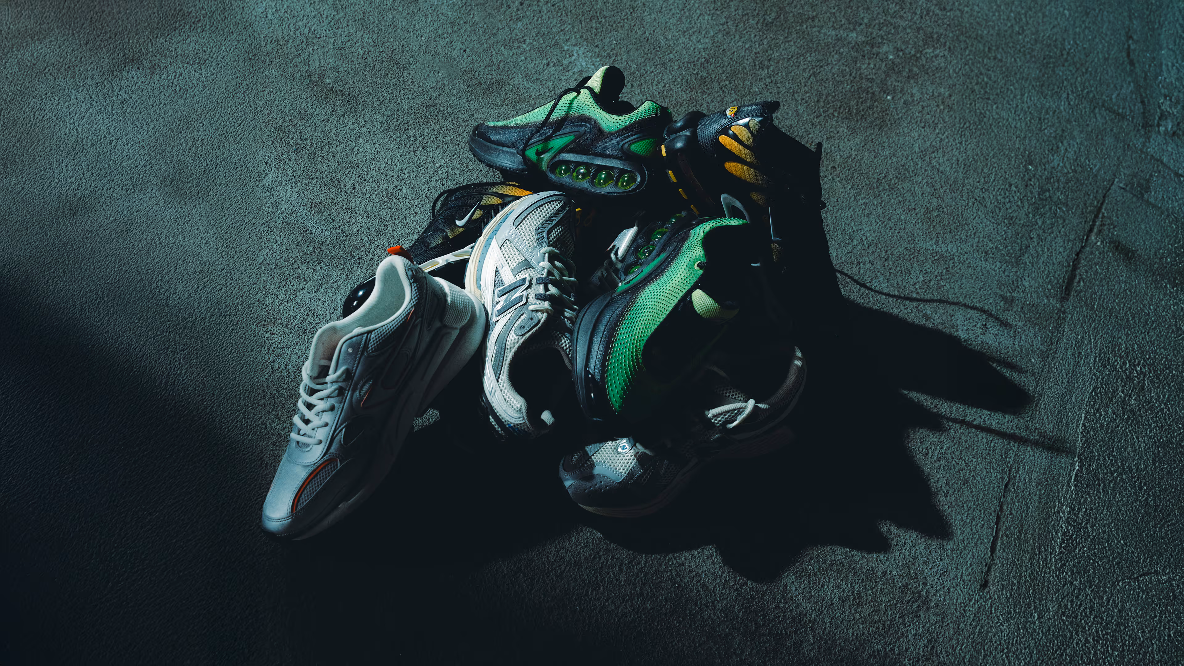 NEA Studio campaign photography, Pilatos sneaker collection stacked on concrete floor with dramatic street lighting for The Movement campaign film